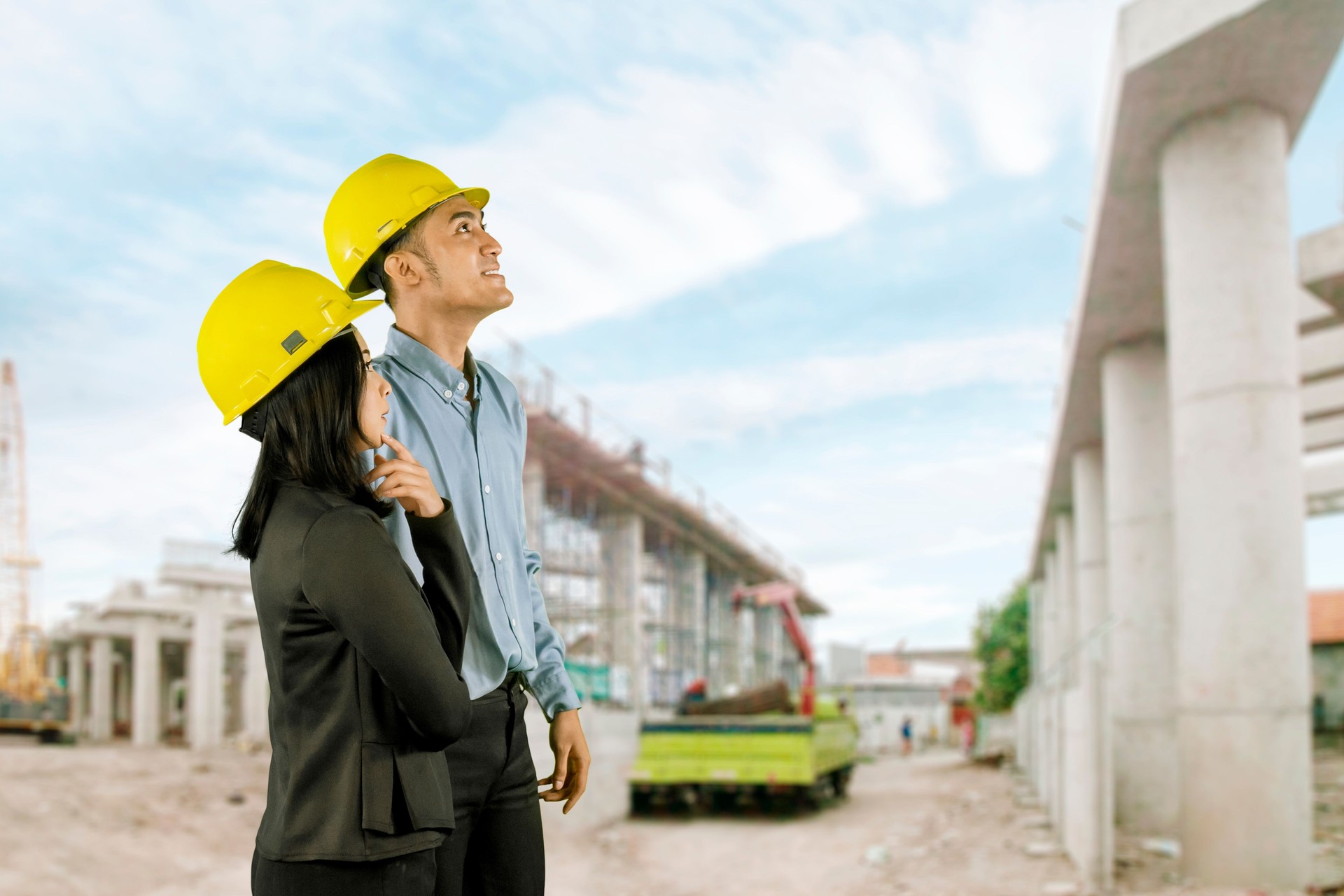 Engineers Overseeing Construction Site Progress with Safety Helmets