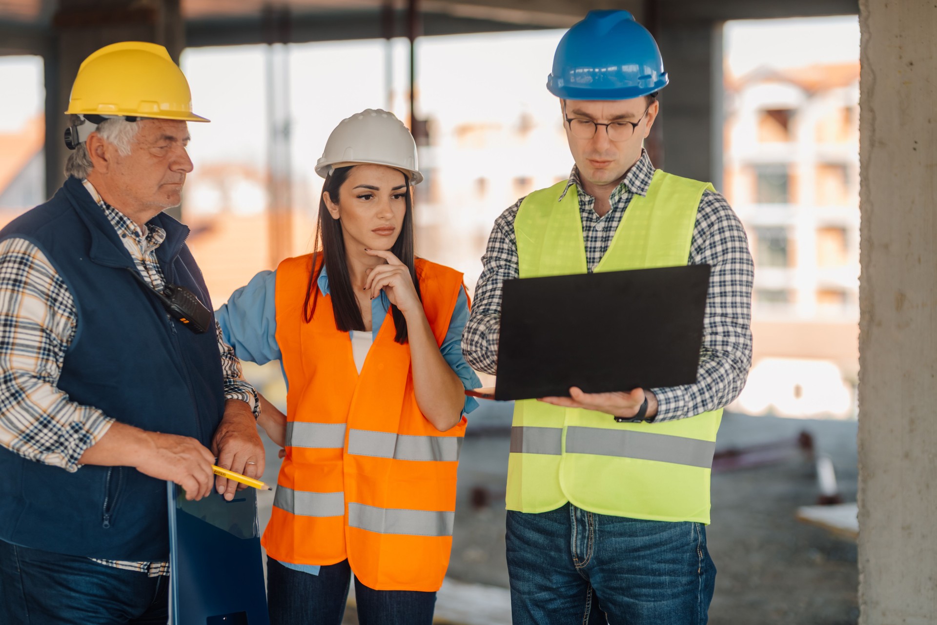 Engineers using laptop discussing project at construction site